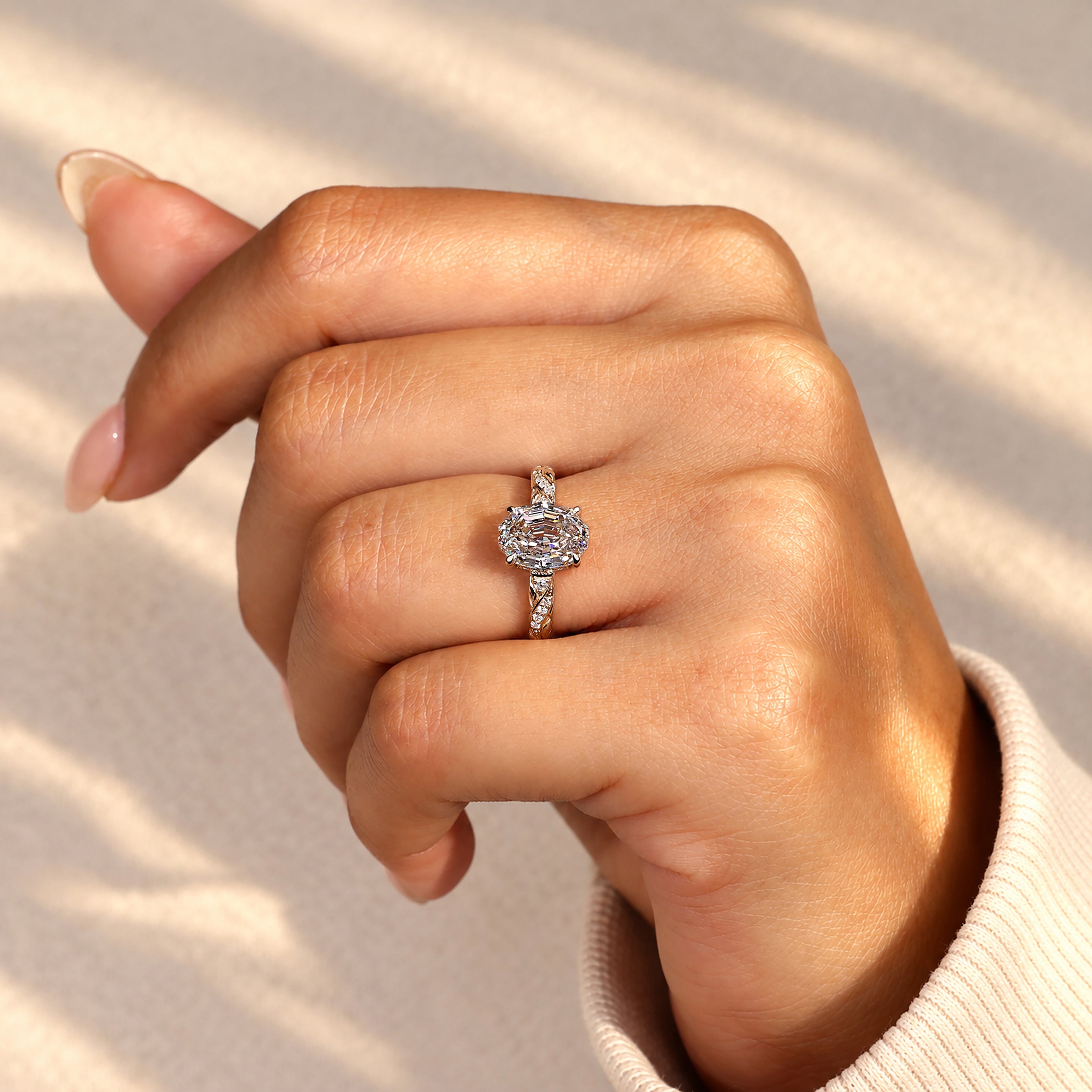 Oval step cut diamond ring with round side stones
