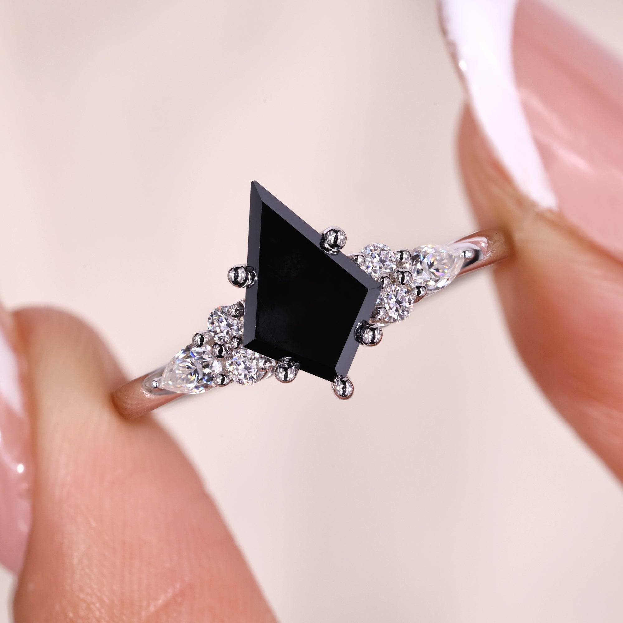 Kite cut engagement ring with tapered shank and side stones.