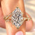 Marquise diamond engagement ring with leaf prongs.
