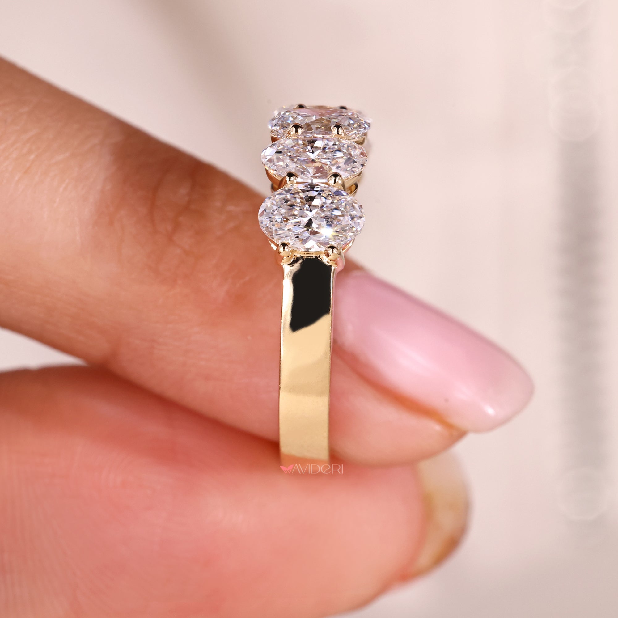 Half eternity wedding band featuring oval diamonds.