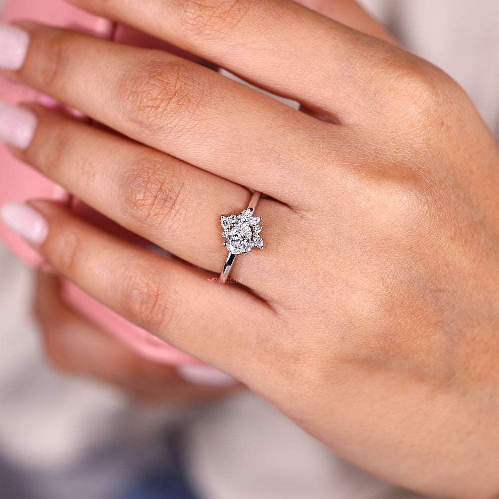 Oval diamond ring with marquise and round side stones.
