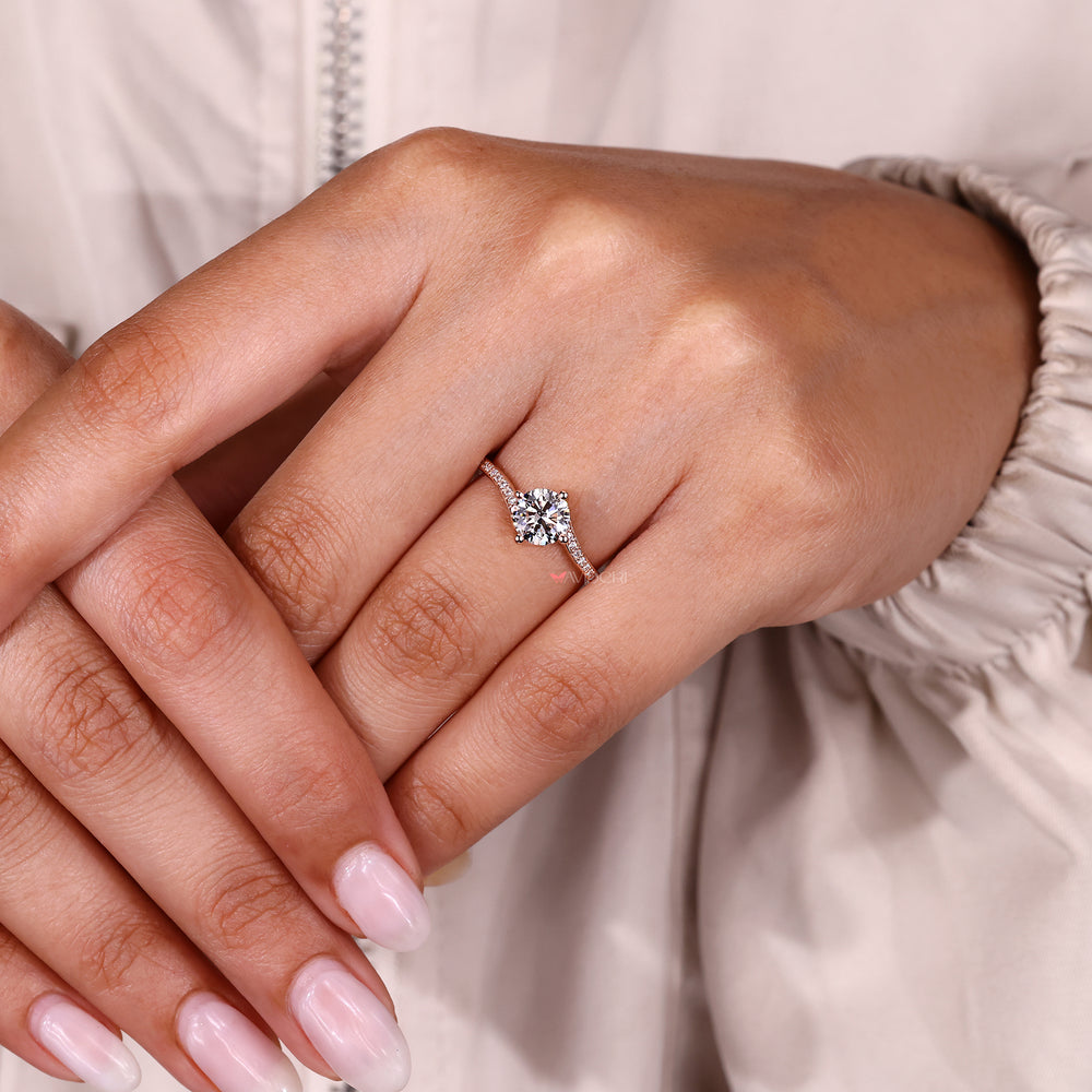 Round diamond engagement ring with compass prong setting.
