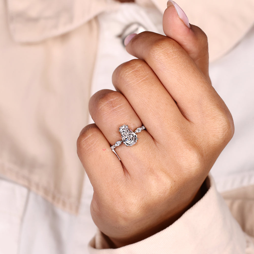 Coffin cut diamond ring with pave band and side stones.