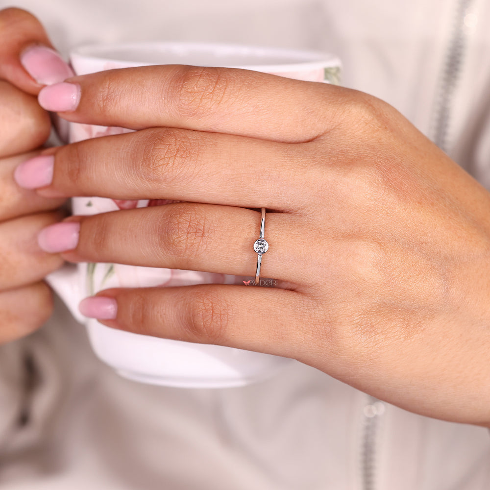Round diamond bezel ring with minimalist design.
