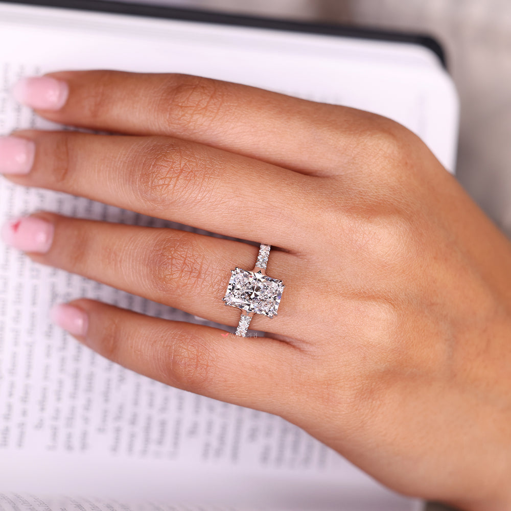 Radiant cut ring with round diamond pave band design.
