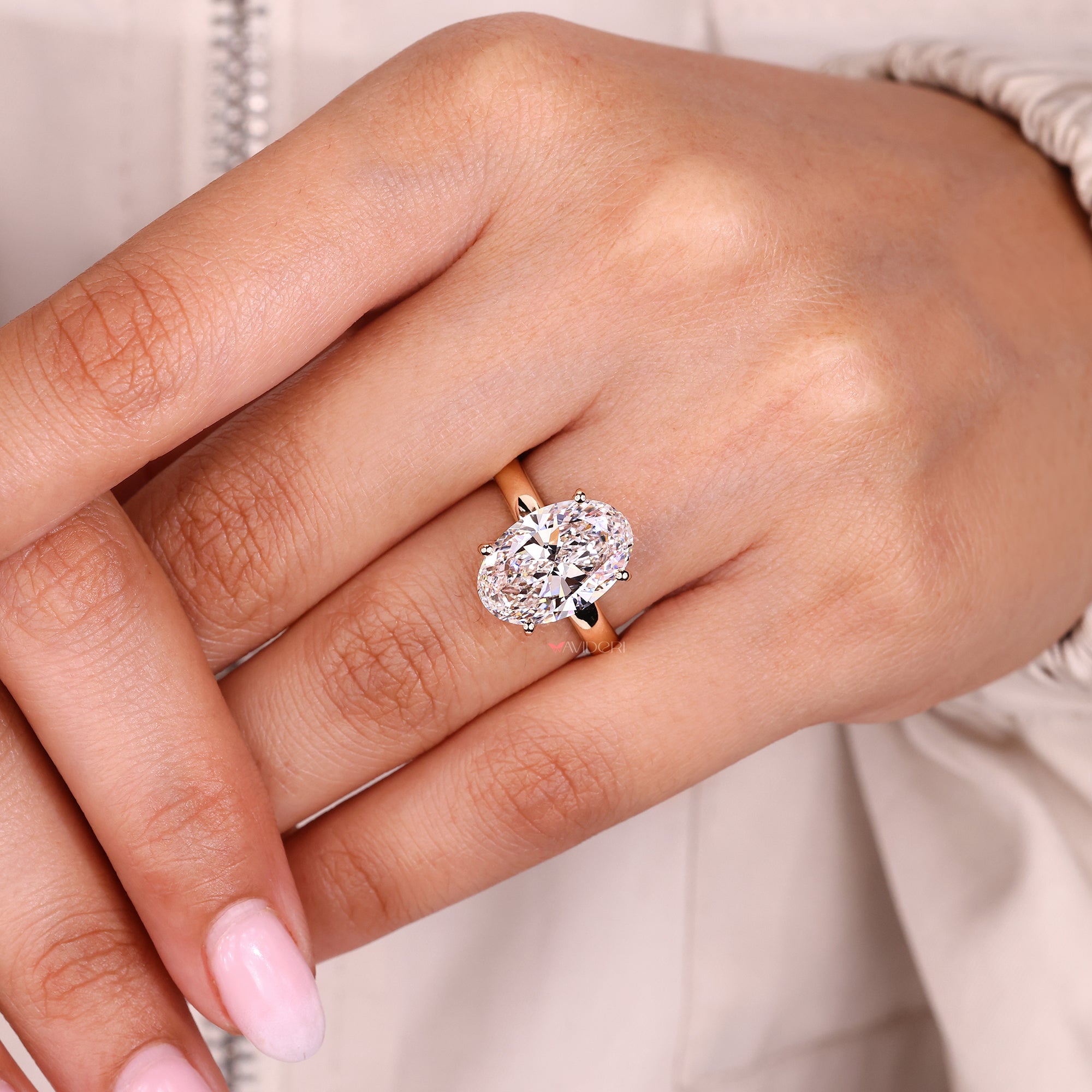 Oval cut hidden halo diamond ring with round diamonds.
