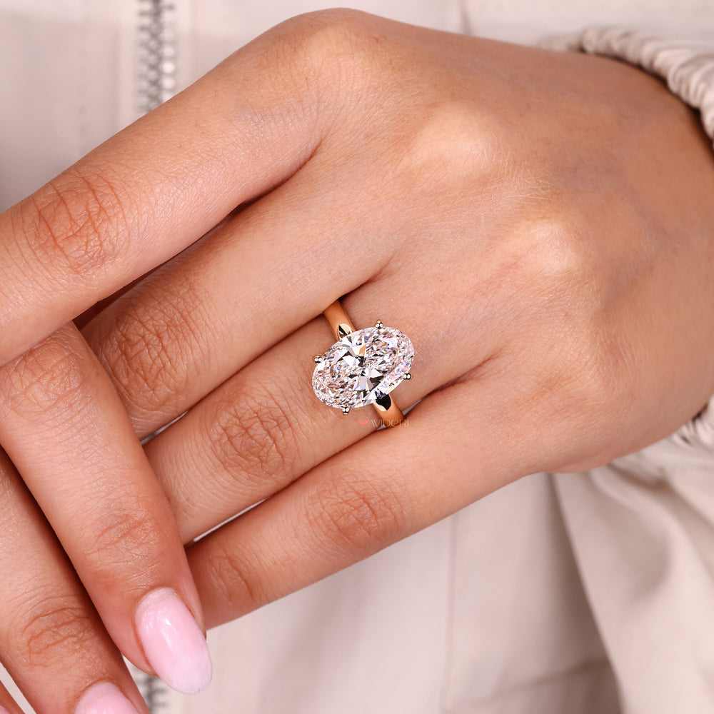 Oval cut hidden halo diamond ring with round diamonds.
