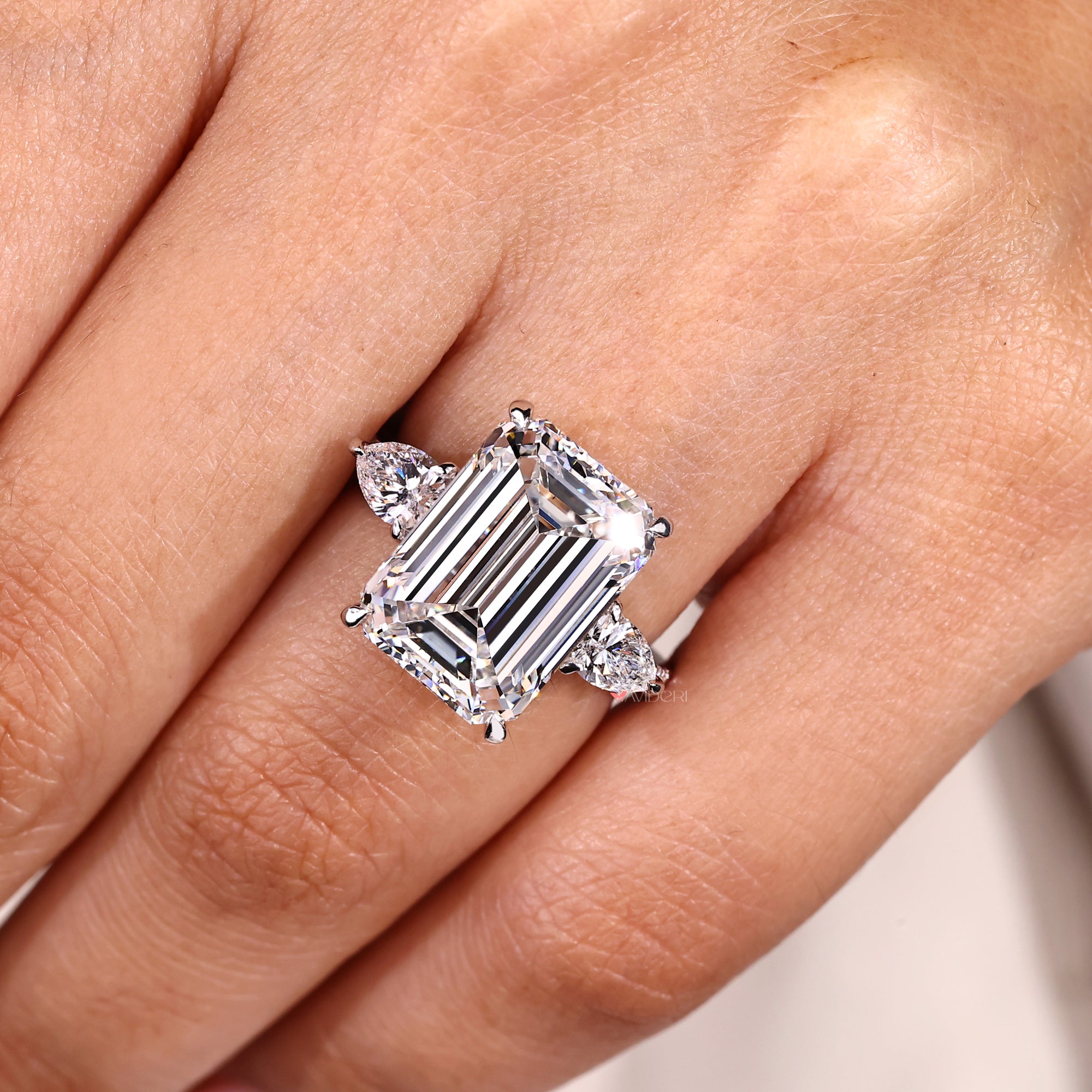 Handmade emerald cut diamond ring with pear side stones.
