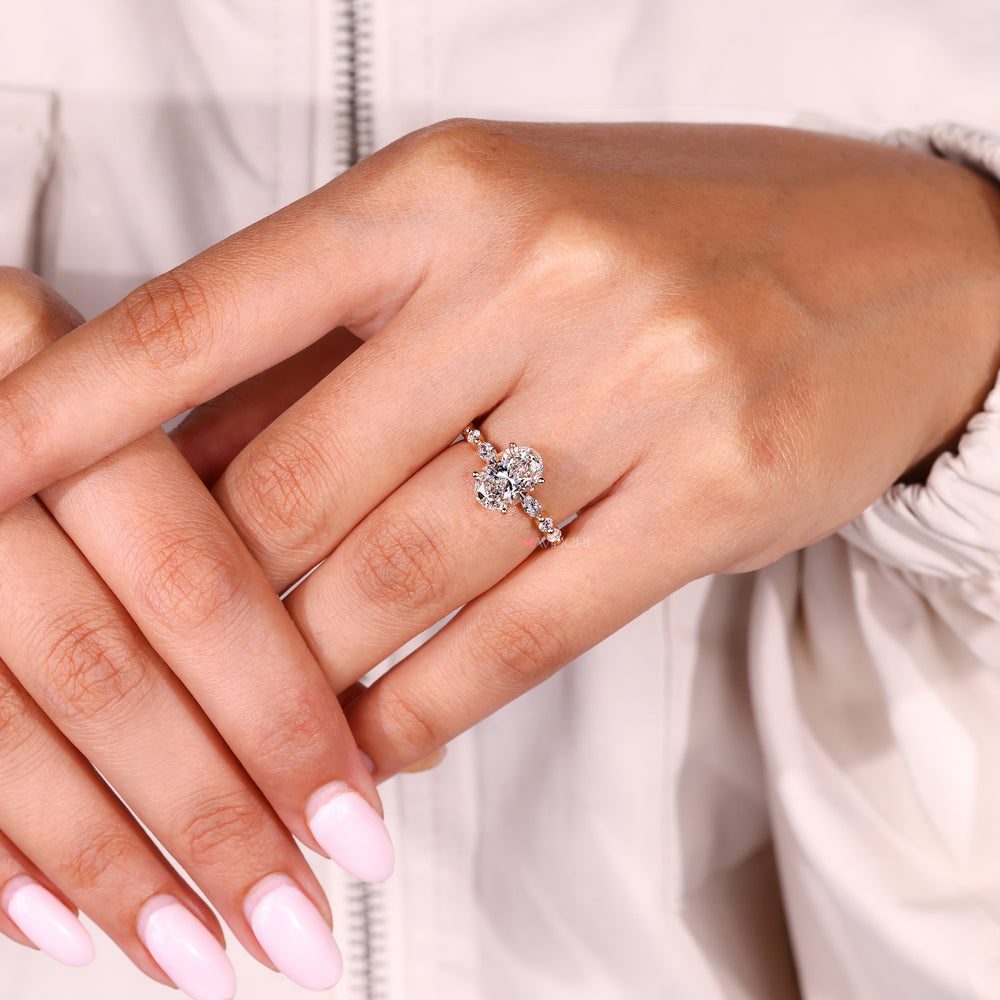 Oval diamond ring with marquise and round side stones
