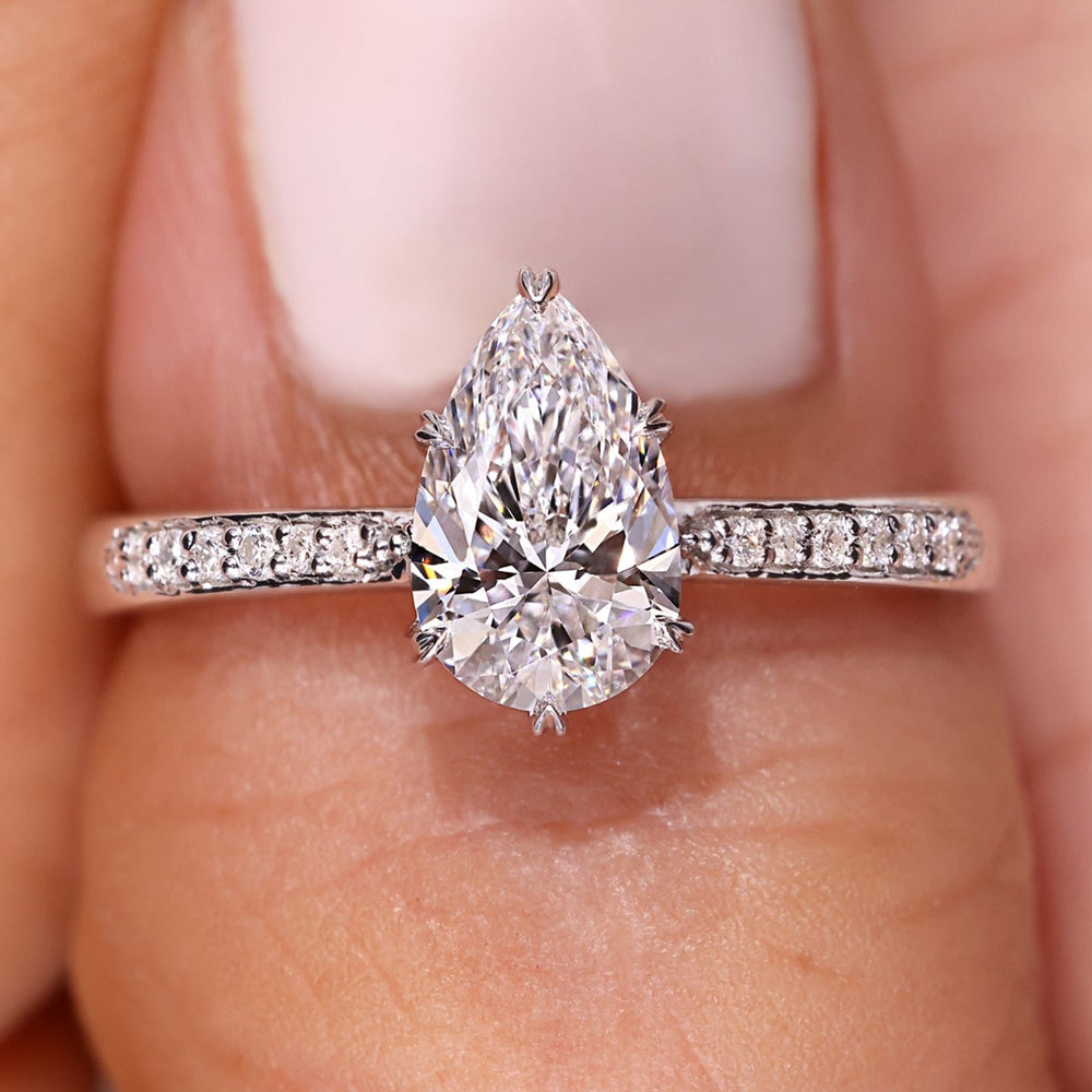 Pear diamond engagement ring with round side stones.