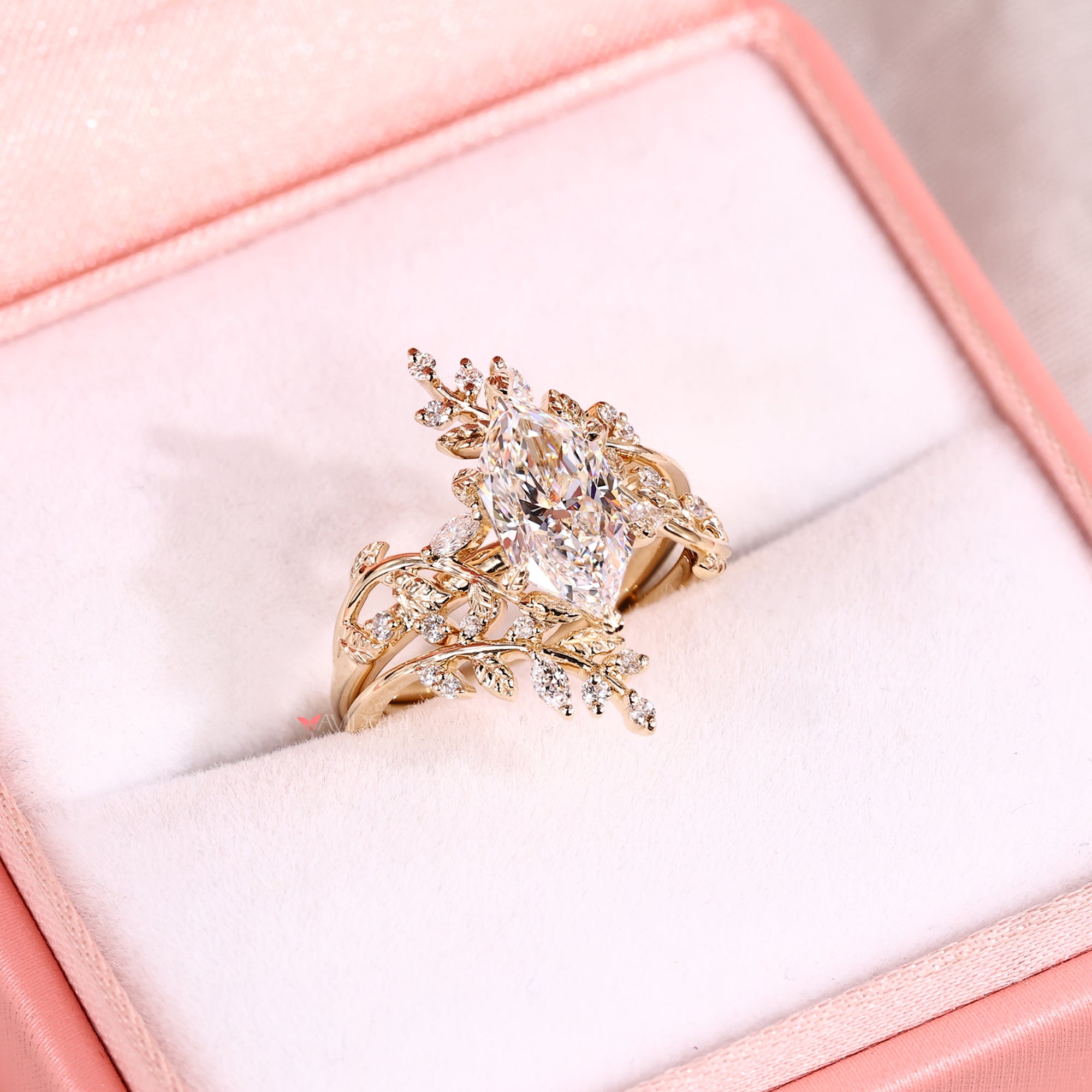 Elegant gold ring with diamonds on a pink cushion in a jewelry box
