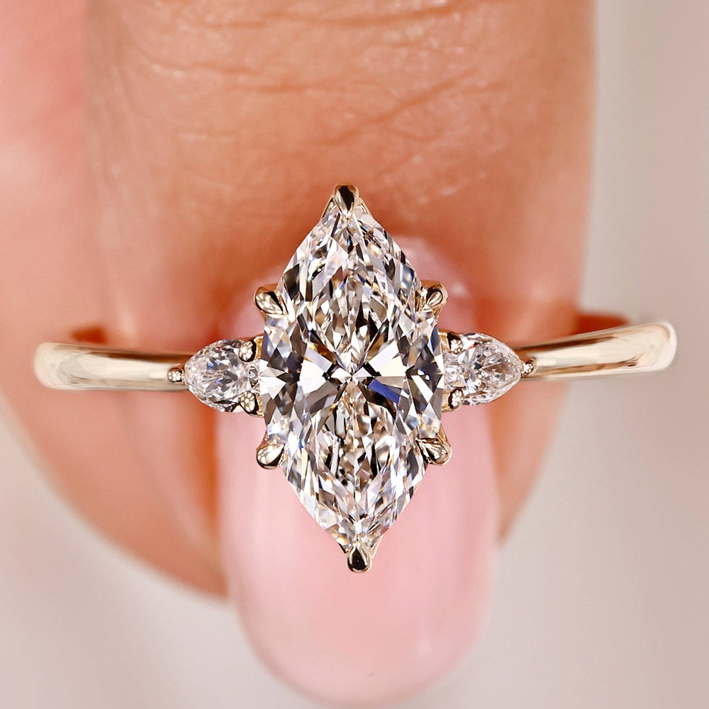 3 stone anniversary ring featuring elegant marquise and pear diamonds.