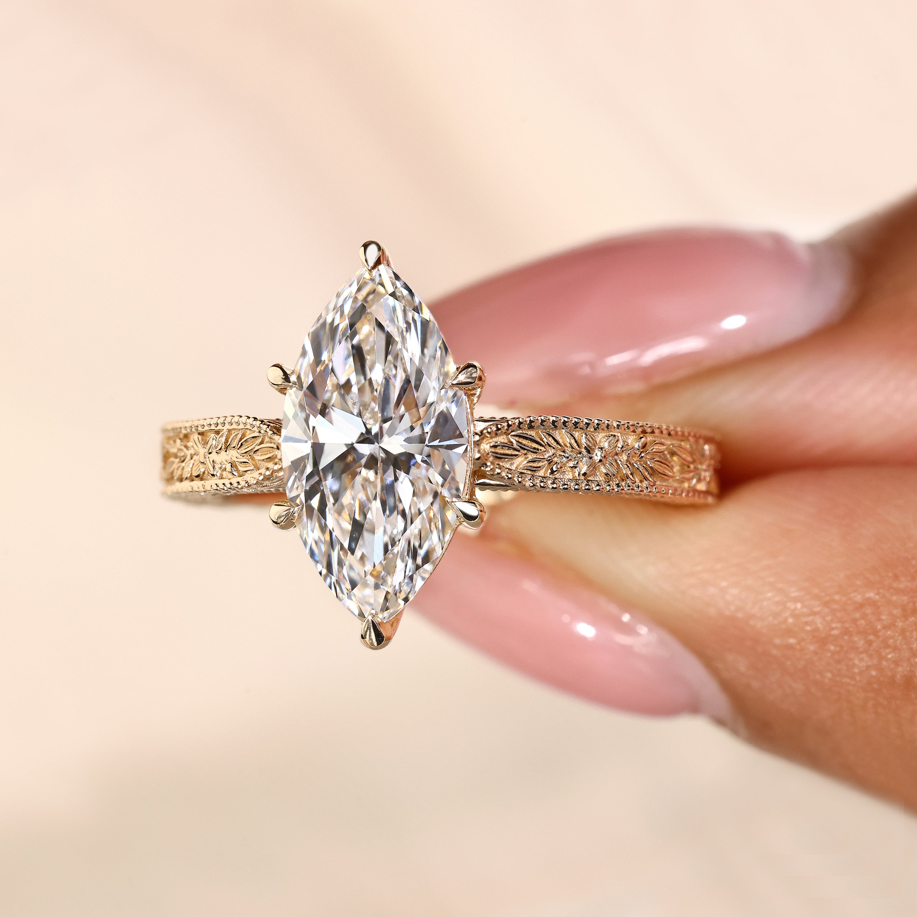 Filigree engraved engagement ring with marquise diamond solitaire style
