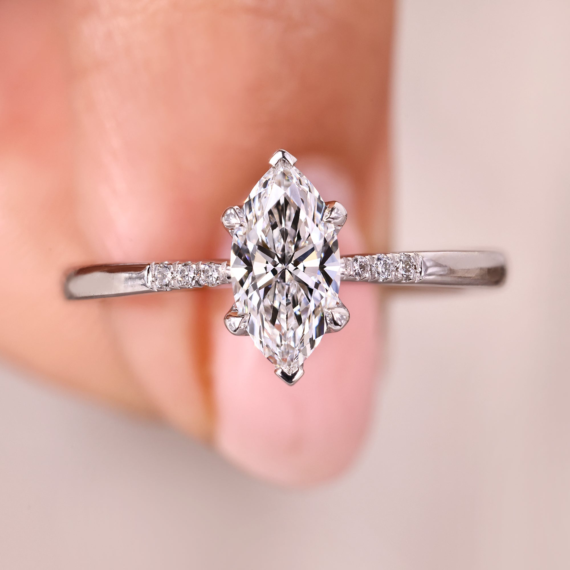 Marquise cut diamond ring in white gold with side stones.