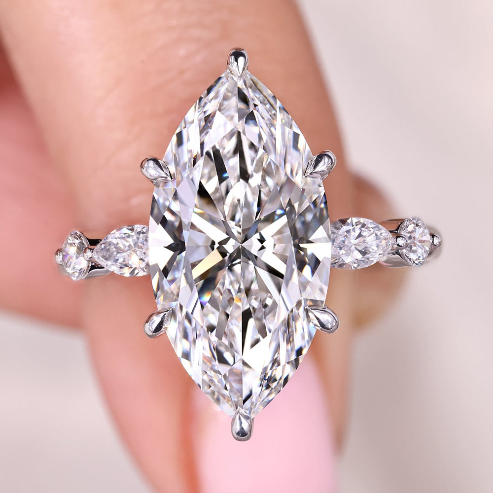 Marquise cut diamond ring with round side stone design.