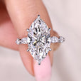 Marquise cut diamond ring with round side stone design.
