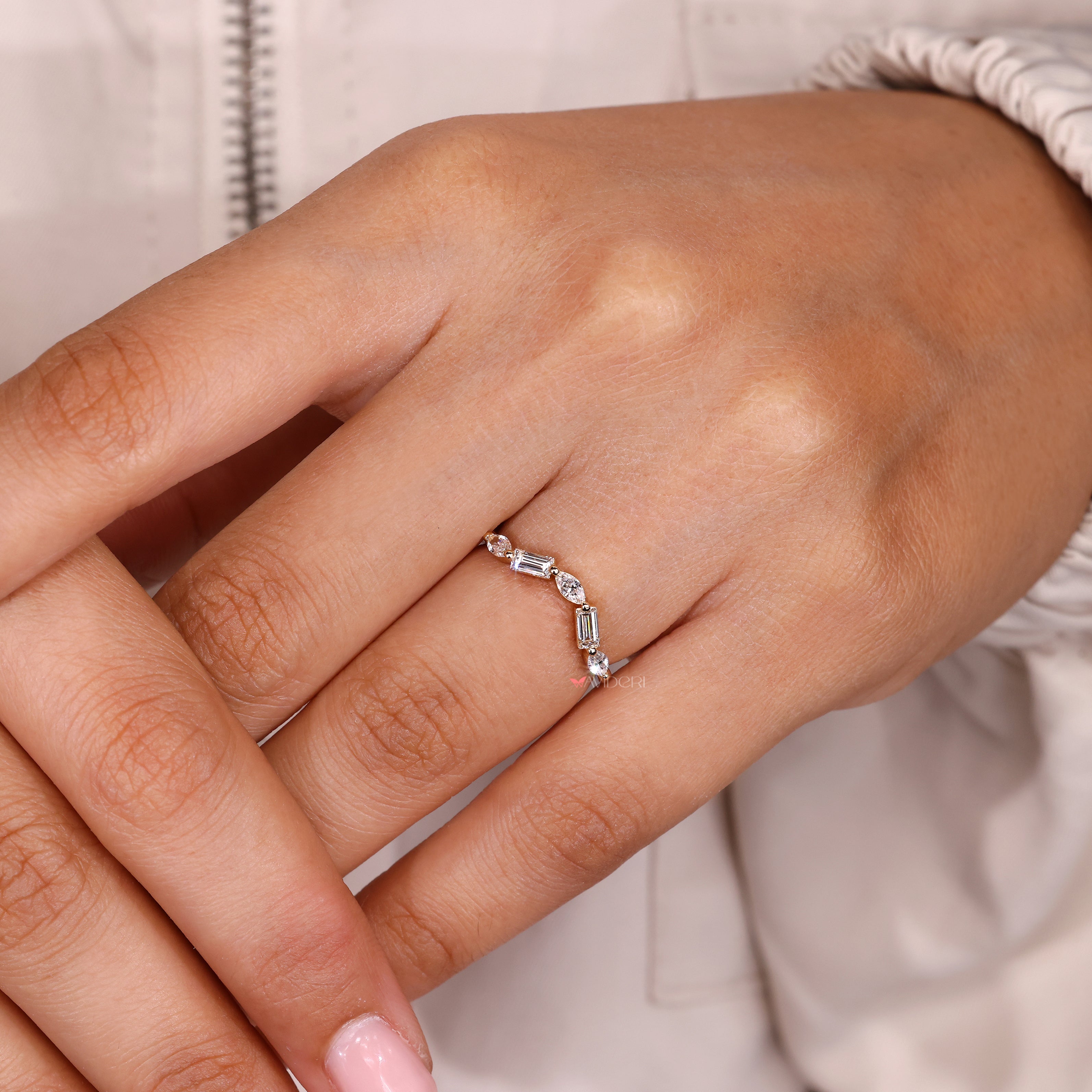 Curved diamond ring with baguette and marquise stone arrangement.
