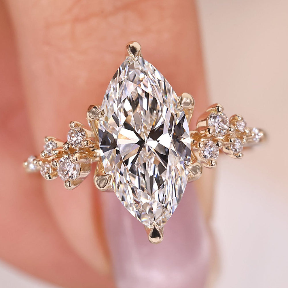 Marquise diamond engagement ring set in yellow gold, featuring a sleek design.
