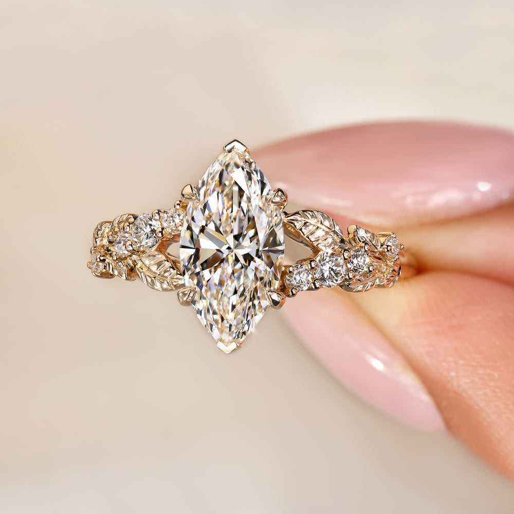 Marquise diamond ring with round stone accents.
