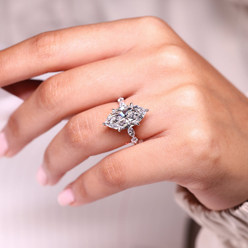 Round side stone ring with marquise center diamond.