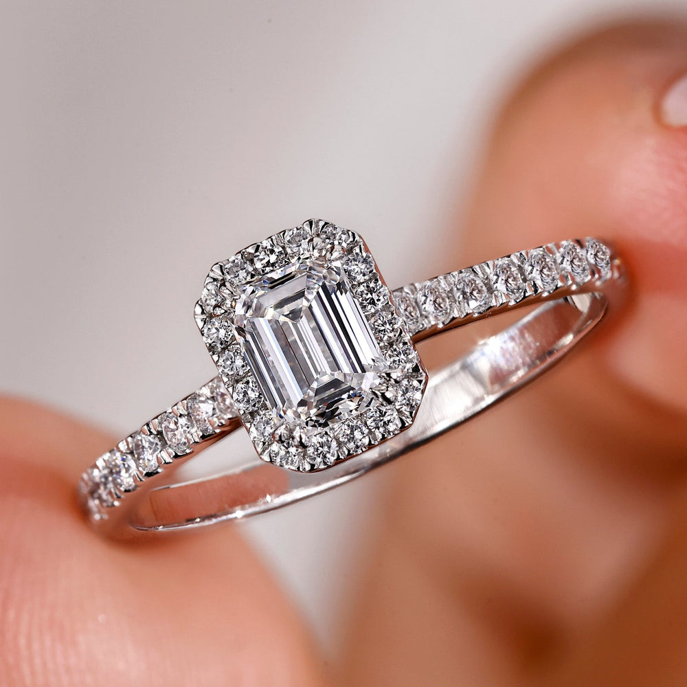 Emerald diamond ring with a halo setting.
