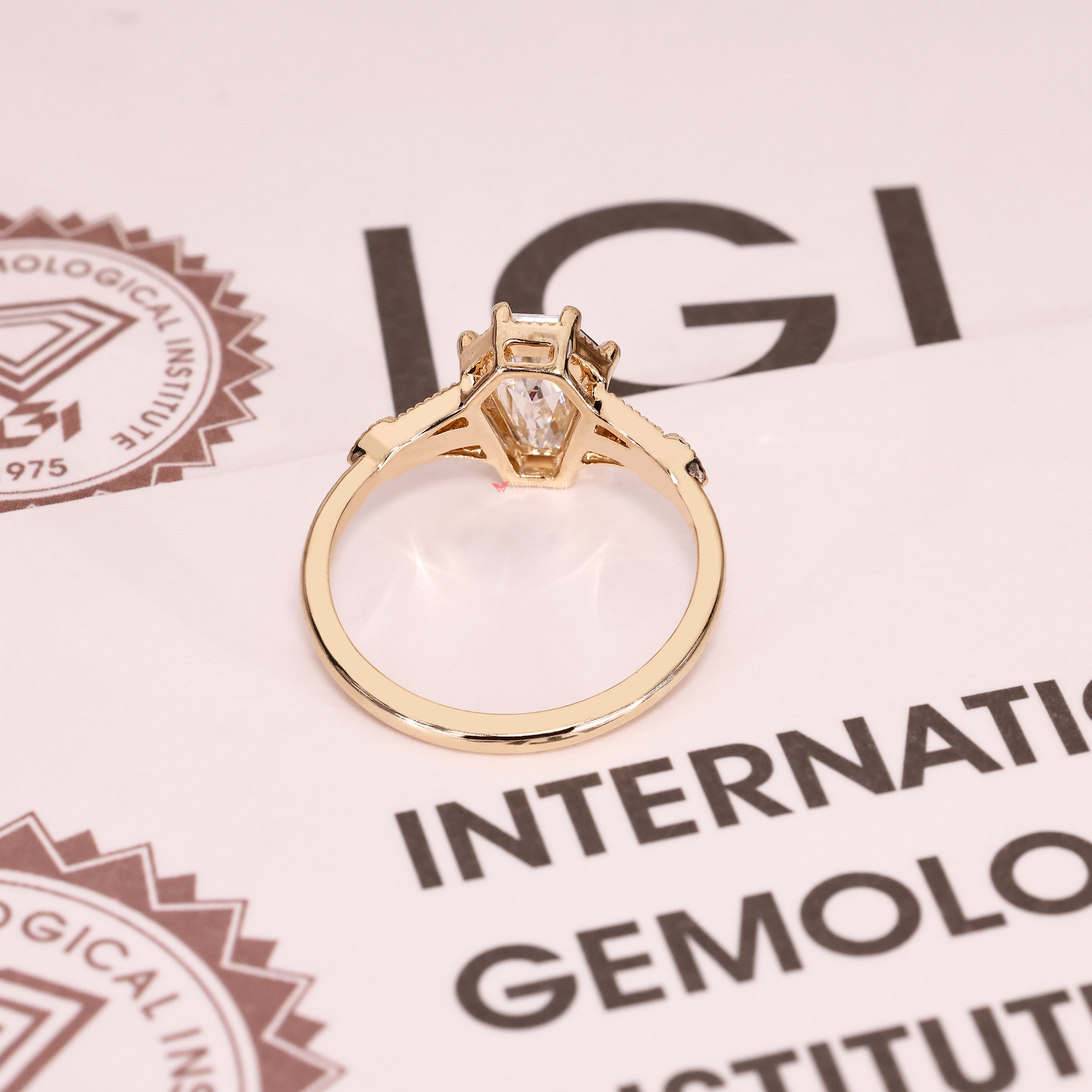 Shield cut lab diamond ring with six claw prongs.
