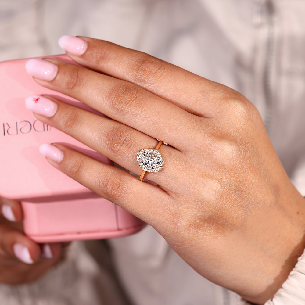 Oval engagement ring with vintage halo and milgrain detail.