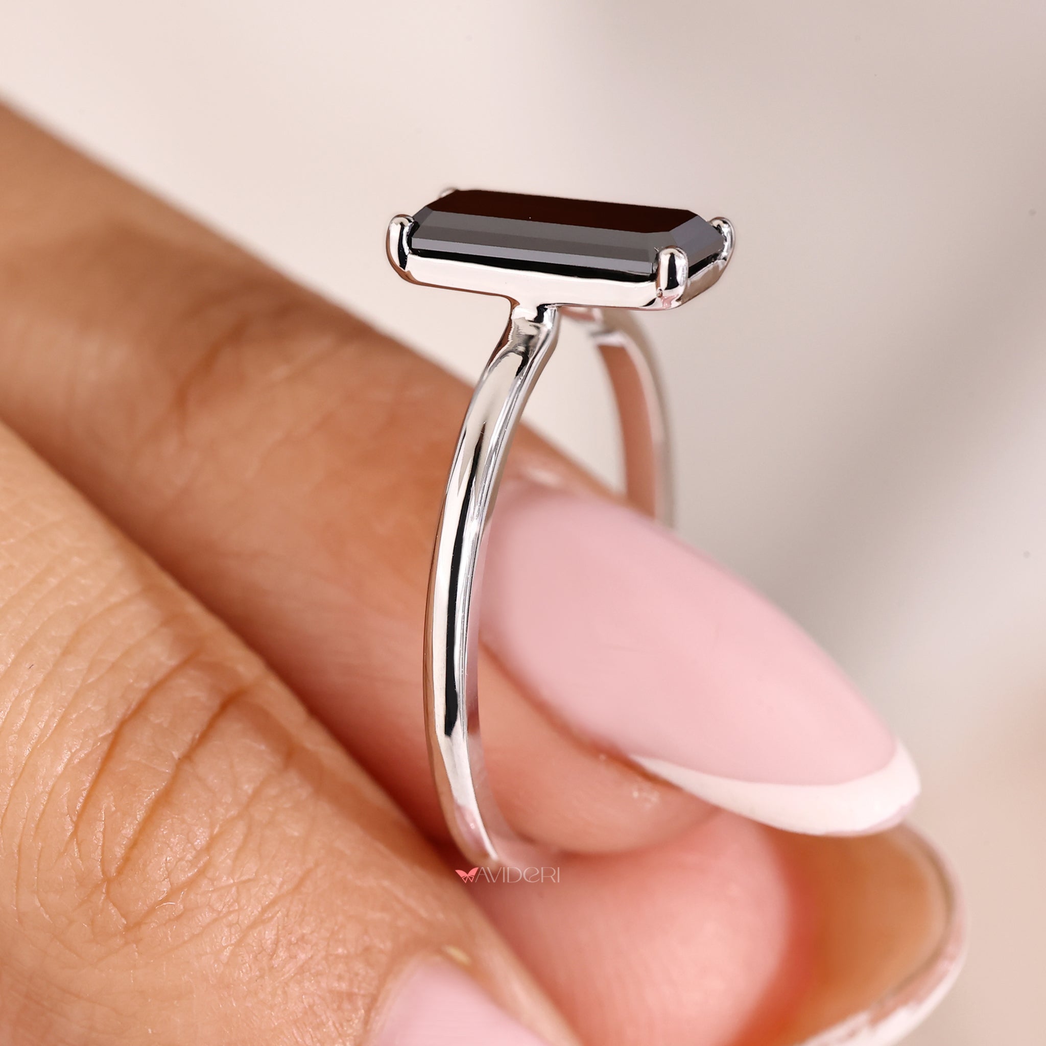 Black moissanite ring designed with an emerald portrait cut centerpiece.
