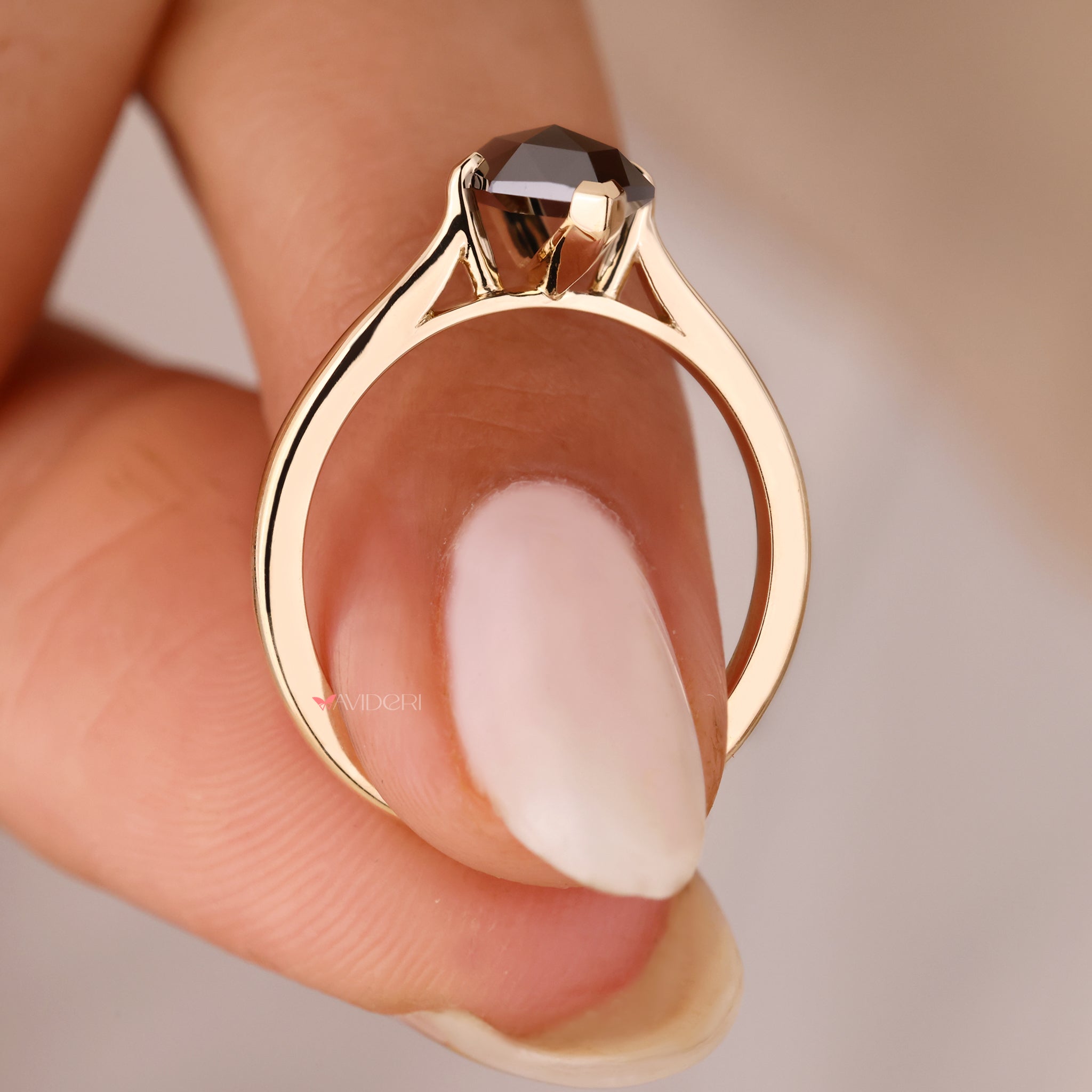 A black moissanite engagement ring on a handmade Yellow gold band.

