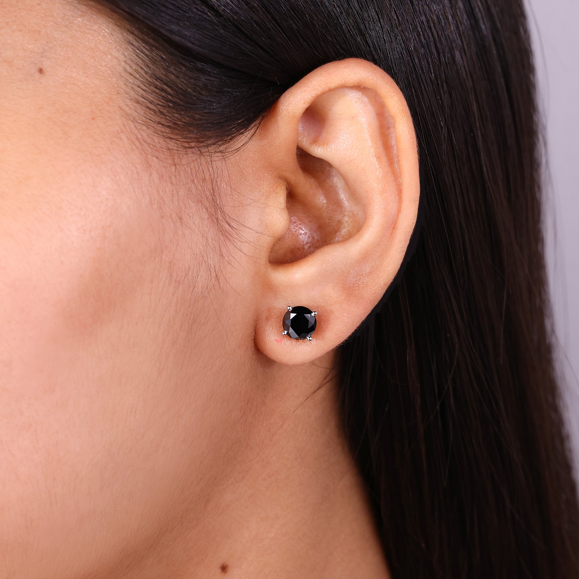 Handmade earrings with a round cut moissanite stone in white gold.