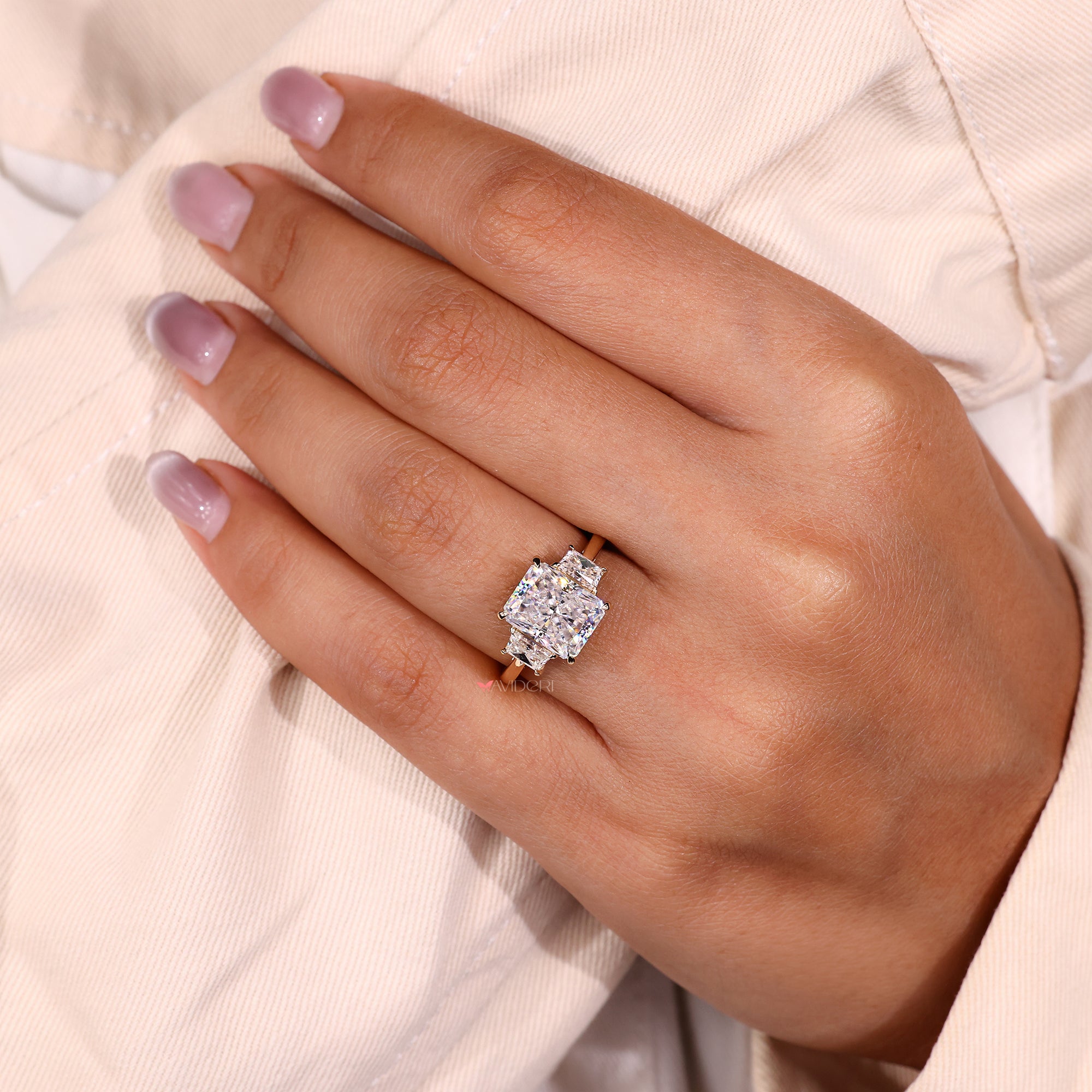 Radiant cut moissanite ring with sleek side stones.
