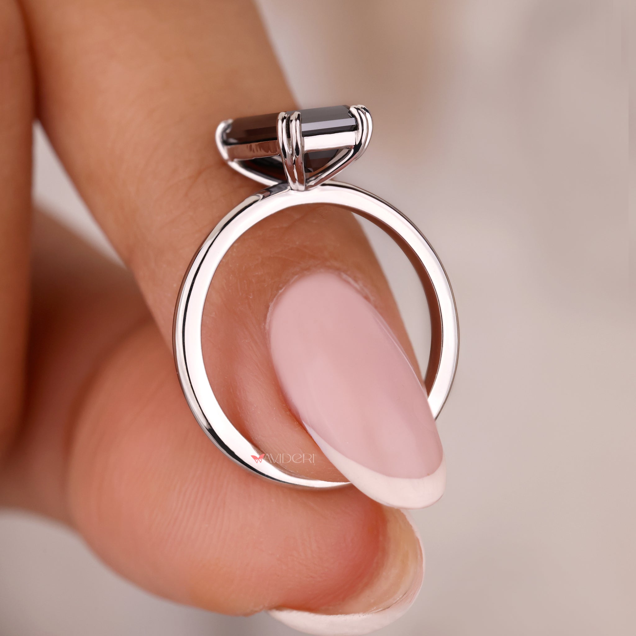 Elongated emerald cut engagement ring with a sleek white gold band
