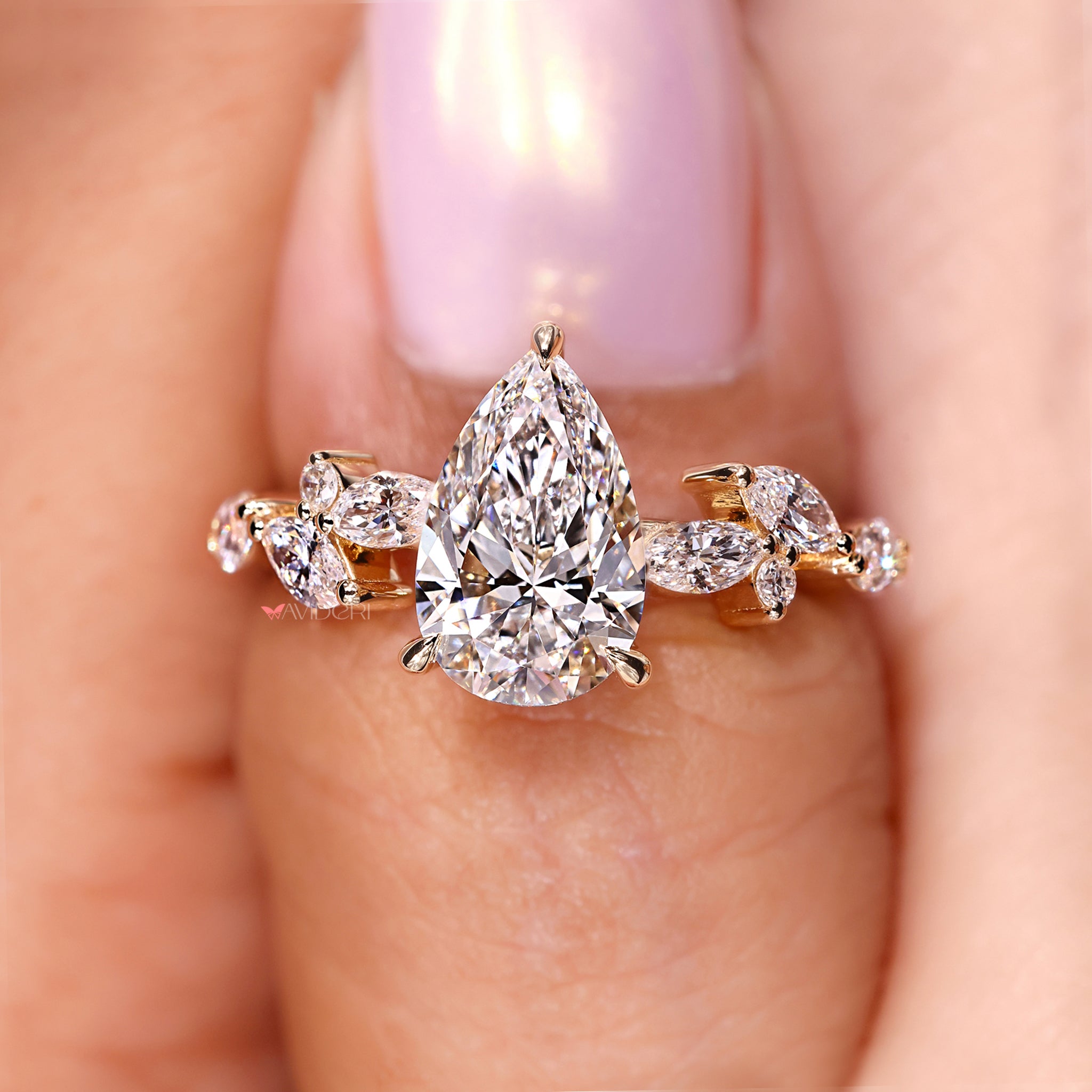 Marquise and round side diamond engagement ring with a nature-inspired yellow gold band.
