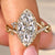 Marquise diamond ring with twisted pave shank.
