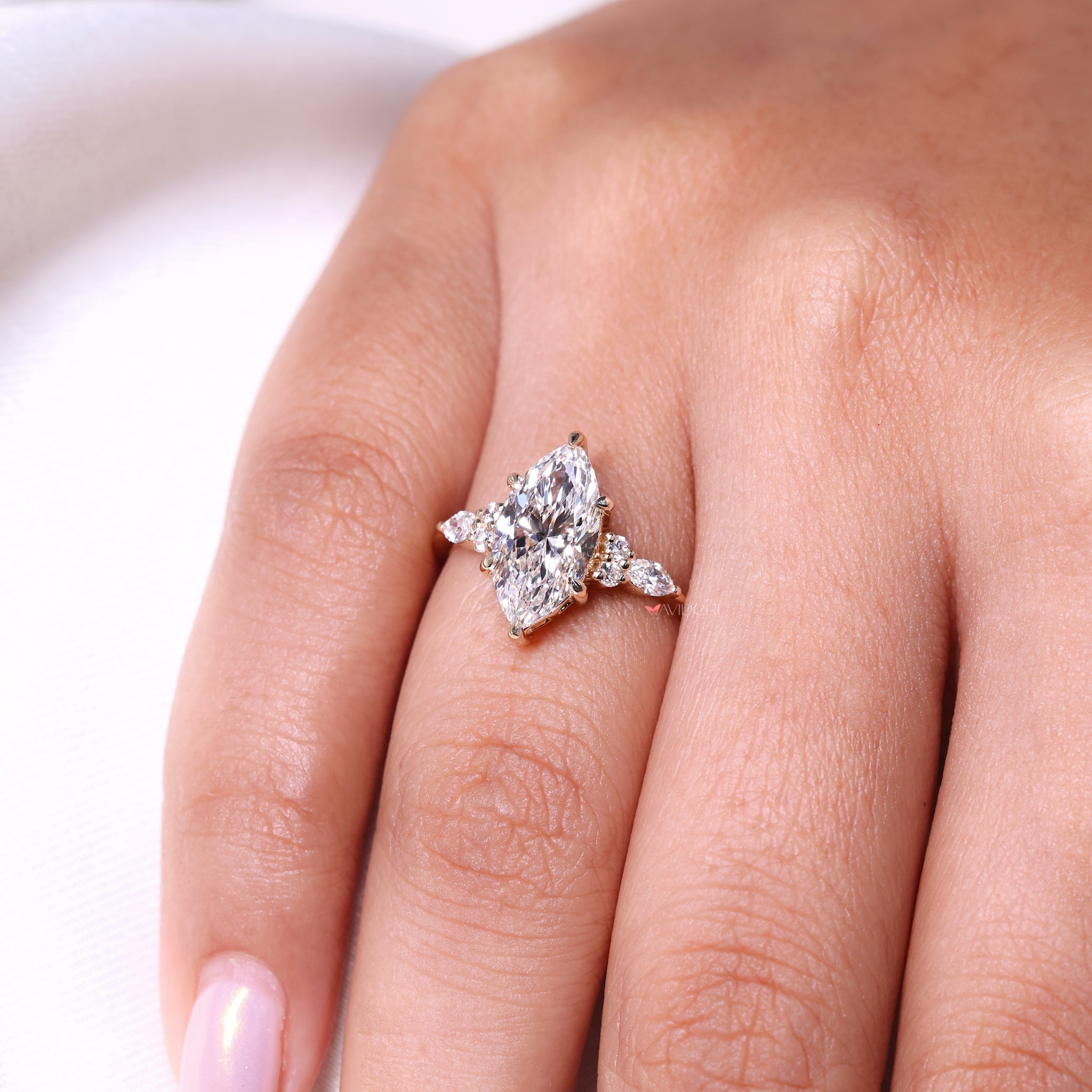 Marquise and round side stone design adds sparkle and balance.