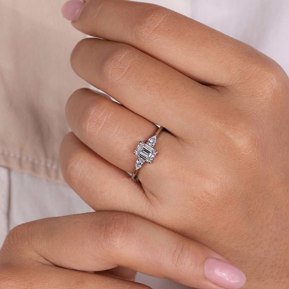 Emerald cut emerald ring with 3 stone diamond ring accents, combining vibrant beauty with stunning craftsmanship.
