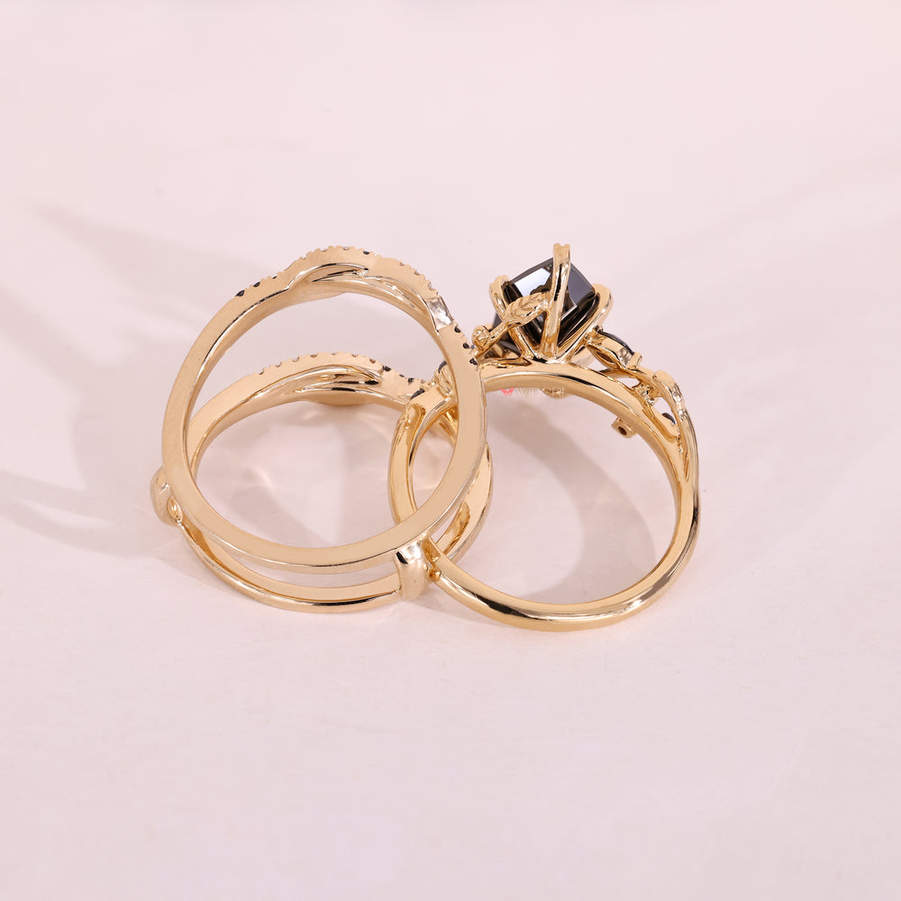Yellow gold bridal set featuring black moissanite and leaf prong setting.