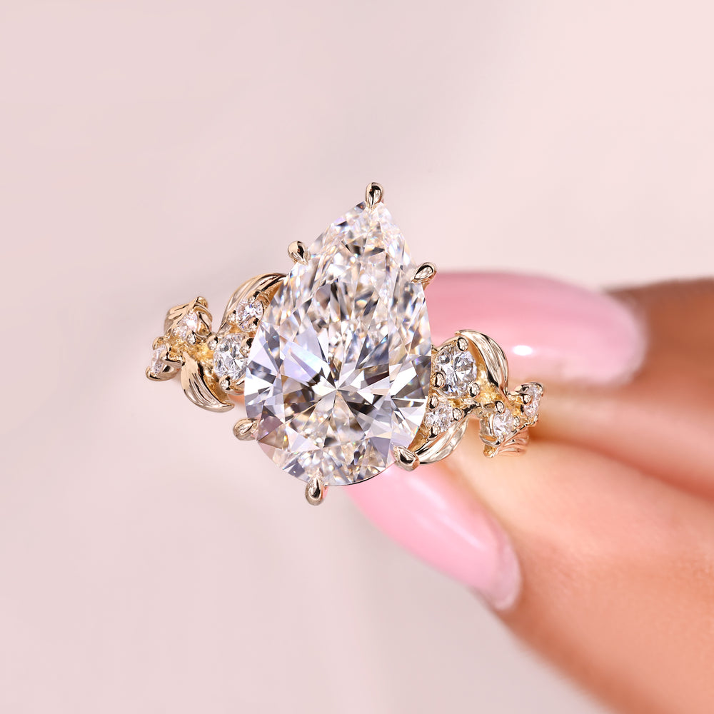 Pear cut diamond ring featuring round side stones.
