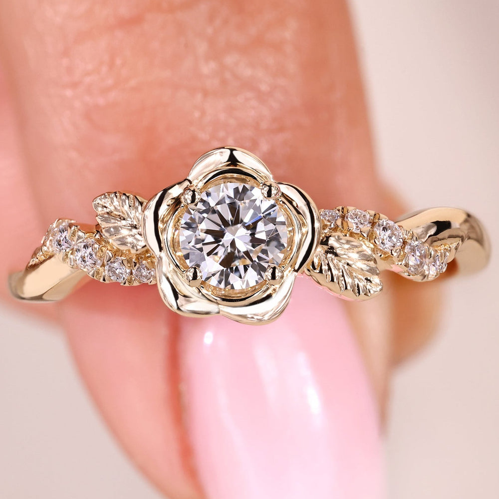 Floral engagement ring with a brilliant round diamond set in polished yellow gold.