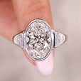 Three stone engagement ring with oval cut center diamond.