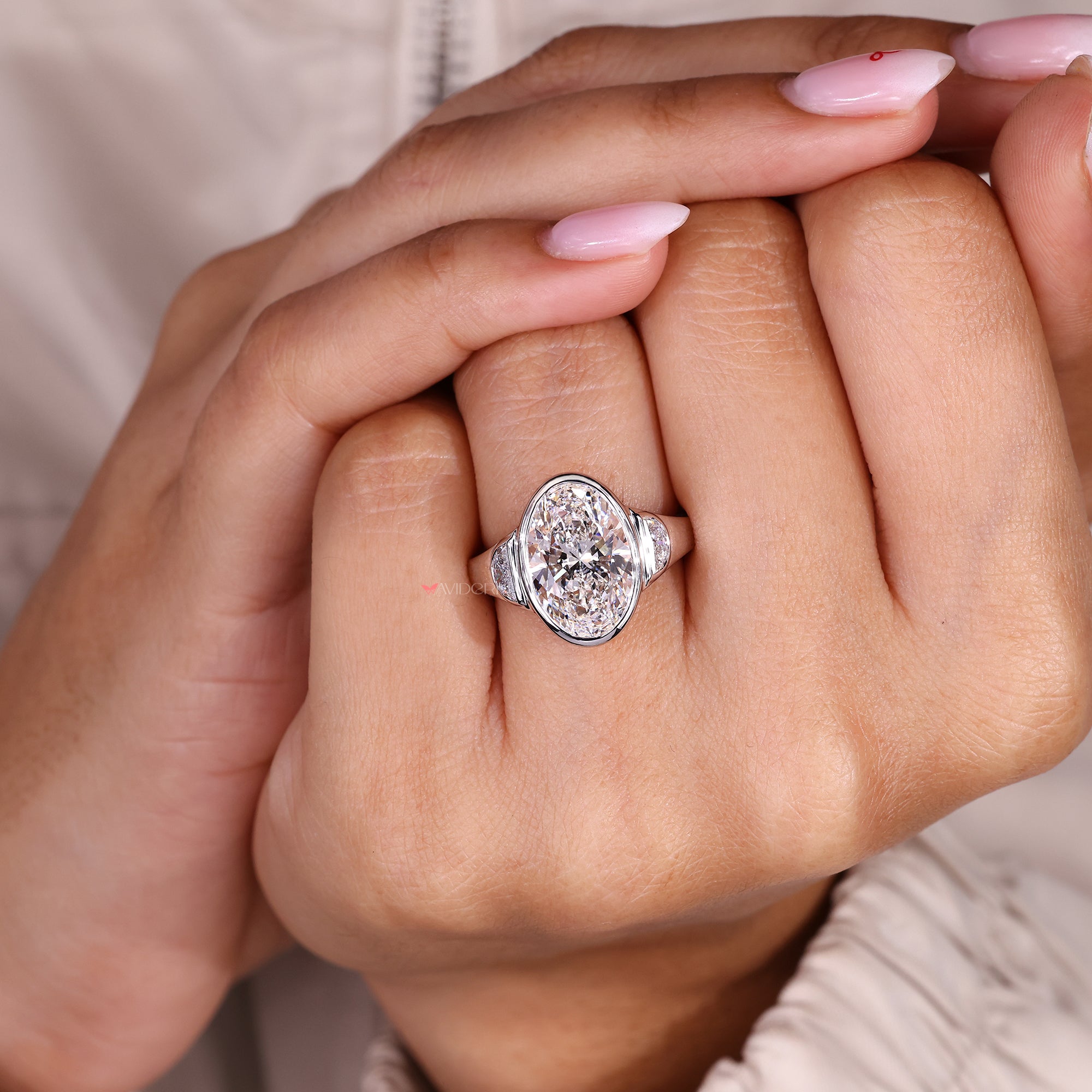 Bezel set three stone engagement ring in white gold.