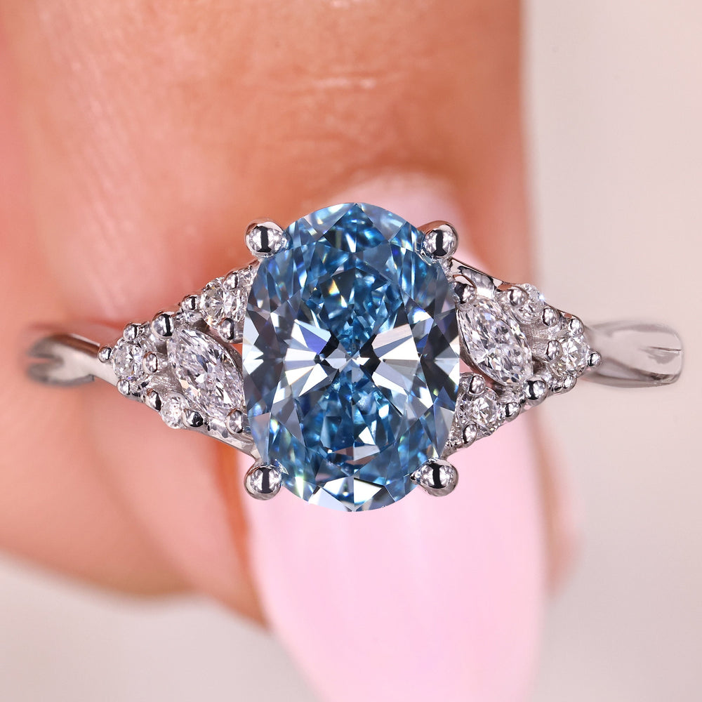Oval cut blue diamond ring with side stones.

