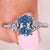 Oval cut blue diamond ring with side stones.
