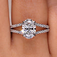 Oval cut diamond ring with hidden halo and split pave band.
