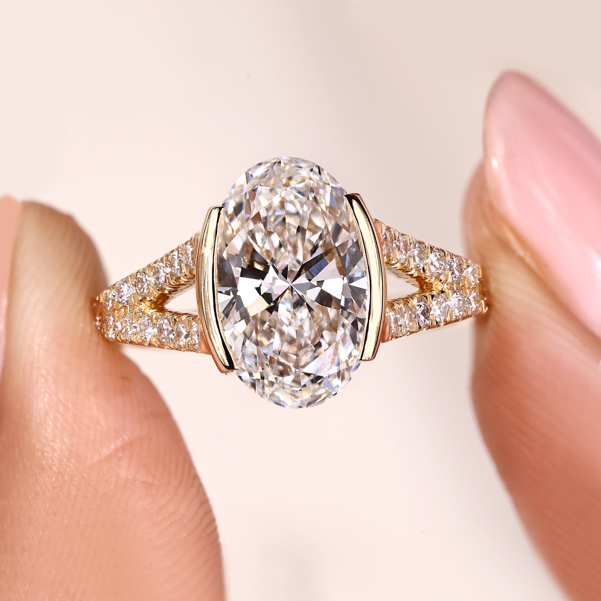 Oval diamond engagement ring with half bezel setting ring.