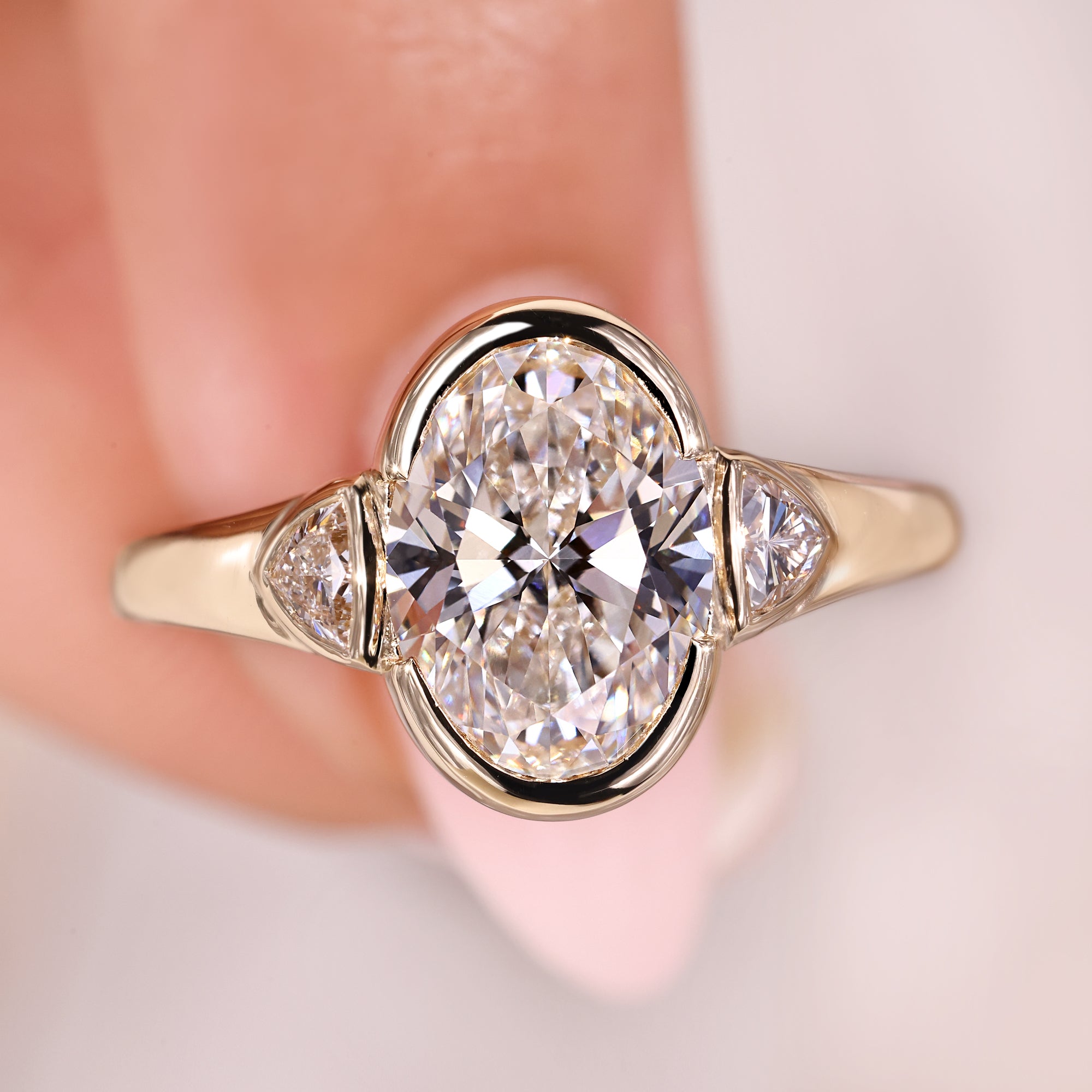 Oval diamond engagement ring with trillion side stones.