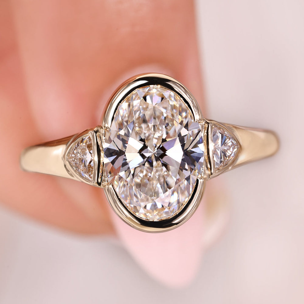 Oval diamond engagement ring with trillion side stones.