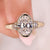 Oval diamond engagement ring with trillion side stones.
