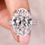 Oval diamond ring with cathedral setting and double row pave band.
