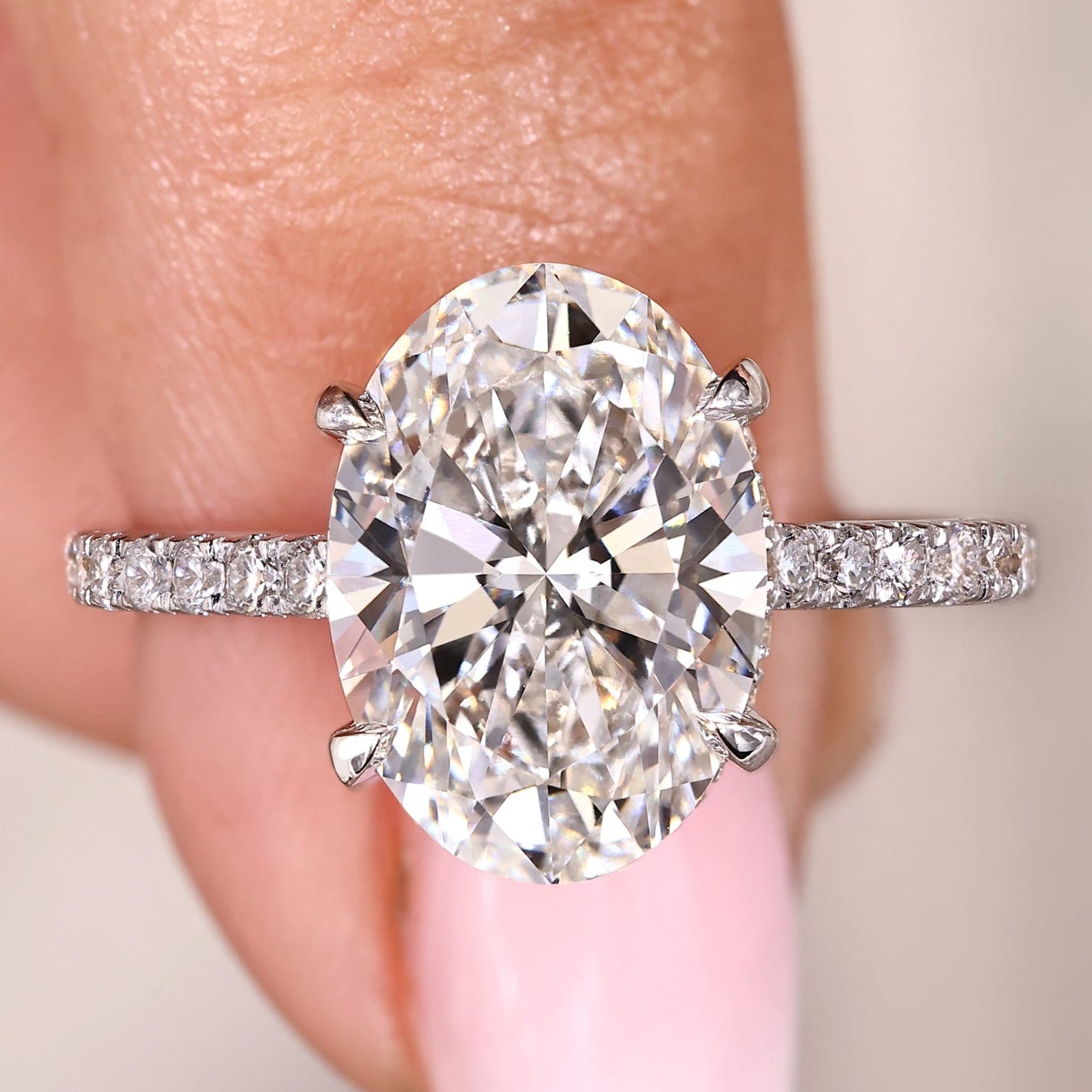 Oval engagement ring with pave band and open gallery.